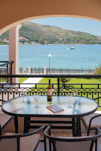 a table with wine glasses and a bottle of wine at Kalamionas Studios & Apartments in Kassiopi