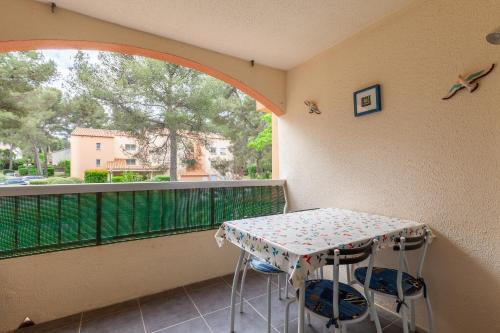 un balcon avec une table, des chaises et une fenêtre dans l'établissement Chez Alain et Martine, à Saint-Mandrier-sur-Mer