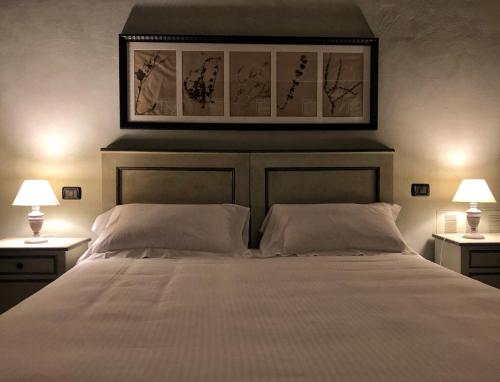 a bedroom with a large white bed with two lamps at Palazzo Contelori in Terni