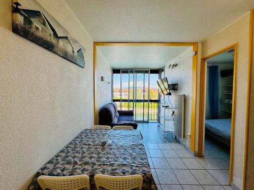 un salon avec une table et un canapé et une cuisine dans l'établissement Escapade Marine Saint Cyprien, à Saint-Cyprien