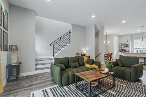 a living room with two green couches and a table at 3br W King Bed, Sauna, Parking-6 Min To Olde Town in Arvada