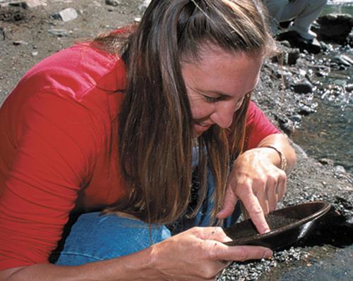 a woman sitting on the ground looking at a bowl at High Grade - Affordable, Near Mendenhall Glacier, Trails, and Conveniences -DISCOUNT ON TOURS! in Mendenhaven