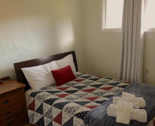 a bedroom with a bed with a quilt and a window at Raw Gold - Affordable, Near Mendenhall Glacier, Trails, and Conveniences - DISCOUNTS ON TOURS! in Mendenhaven