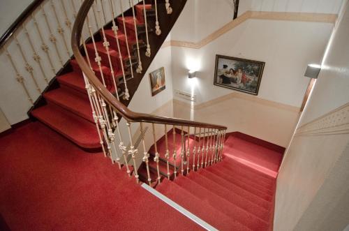 a staircase with red carpeting and a wooden railing at Hotel Polo am ZOB in Hamburg