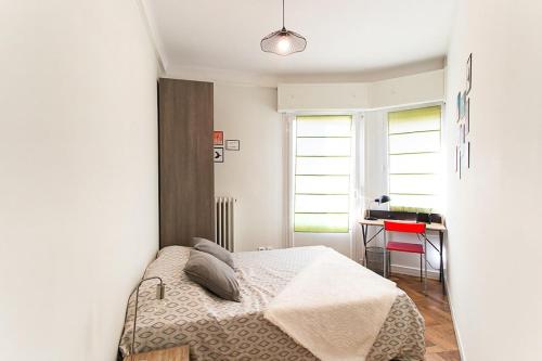une petite chambre avec un lit et un bureau dans l'établissement S7 4 Bedroom flat 10mins walk to Sea and Tramway, à Nice