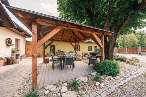 a pavilion with a table and chairs under a tree at Ubytování na statku in Líšnice