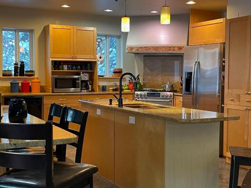 a kitchen with wooden cabinets and a kitchen island with a sink at Home on the Hill at Kelli Creek in Juneau