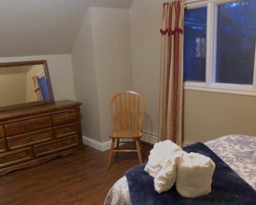 a bedroom with a bed and a dresser and a chair at Mendenhall Private Room In Shared Home - DISCOUNT ON TOURS in Mendenhaven