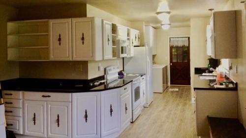a kitchen with white cabinets and a white refrigerator at Mendenhall Private Room In Shared Home - DISCOUNT ON TOURS in Mendenhaven