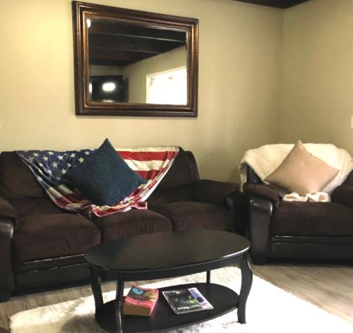 a living room with a couch and a table and a mirror at Mendenhall Private Room In Shared Home - DISCOUNT ON TOURS in Mendenhaven