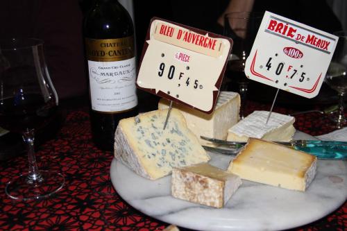 a plate of different types of cheese on a table with wine at La Cadanise, Suite Étoilée in Saint-Éloy-les-Mines