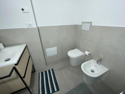 a bathroom with a white toilet and a sink at Vittoria Tre Piazze Apartments in Brescia