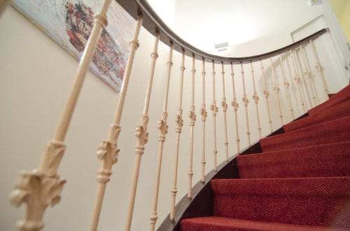 a staircase with red carpeting and white railings at Hotel Polo am ZOB in Hamburg