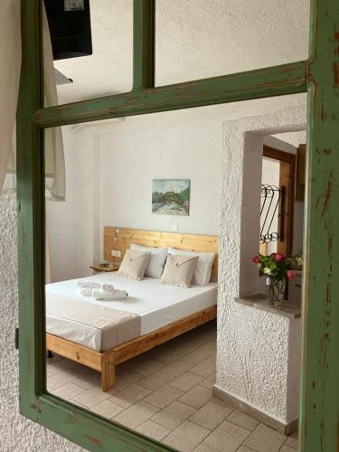 a bedroom with a bed in a room with a mirror at Blue Sea Studios in Limenaria