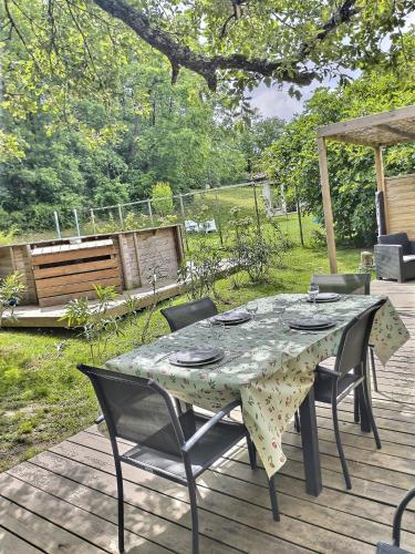 a table and chairs on a wooden deck at Les gîtes de L'Isle Jourdain in Pujaudran