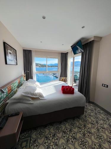 a bedroom with a large bed and a large window at Le Golfe in Porto Pollo