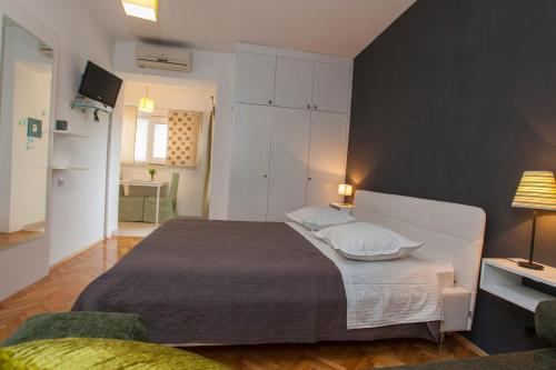 a bedroom with a large white bed with two pillows at Villa Makarana Apartments in Makarska