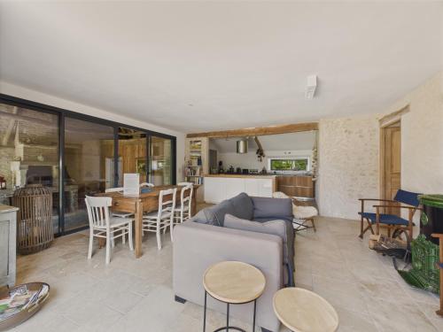 a living room with a couch and a table at Ancienne ferme renovée pour 6 en 2 logements in Fossemagne