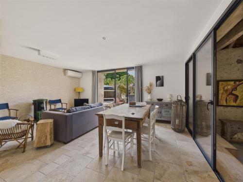 a living room with a table and a couch at Ancienne ferme renovée pour 6 en 2 logements in Fossemagne