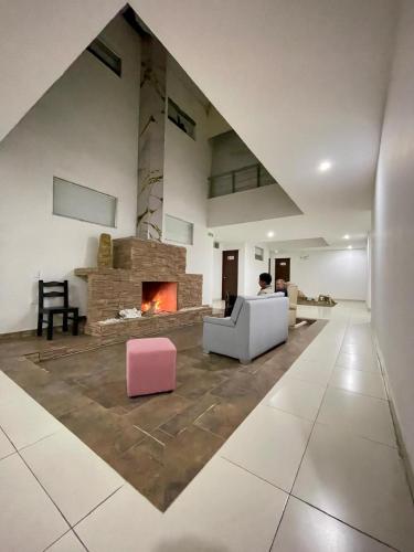 a man sitting in a living room with a fireplace at Hotel Las Piedras San Jose in San José de Isnos