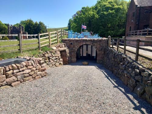a stone gate in a stone wall with a fence at Malthouse Farm Cottage Batcave in Stoke on Trent