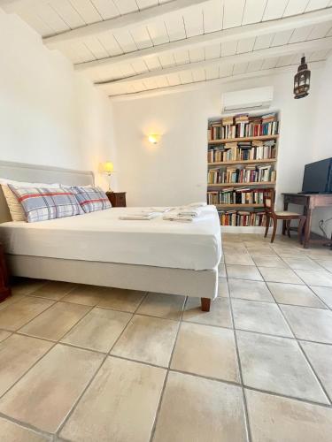 a bedroom with a bed and a tiled floor at Agrari Village Apartment Mykonos in Agrari