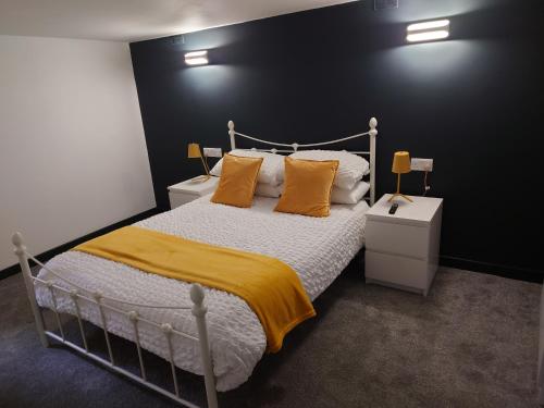 a bedroom with a bed with yellow sheets and pillows at Malthouse Farm Cottage Batcave in Stoke on Trent