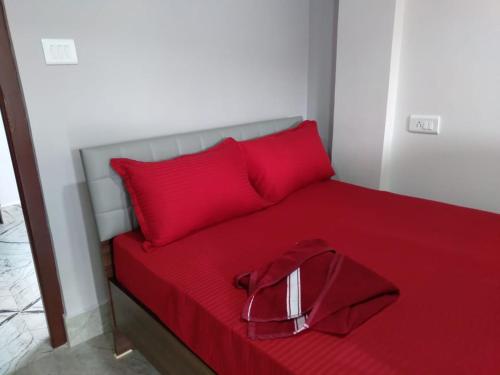 a red bed with two red pillows and a red blanket at Nidaya Guest house in Cherrapunji