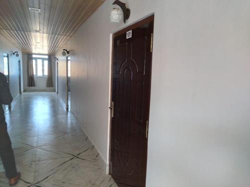 a door in a hallway with a person standing next to it at Nidaya Guest house in Cherrapunji