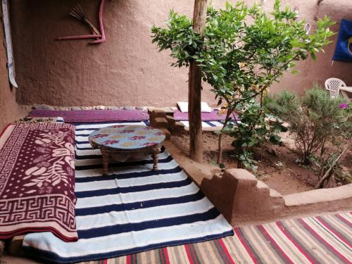 a patio with a table and a rug at Dar itran 2 in Mhamid