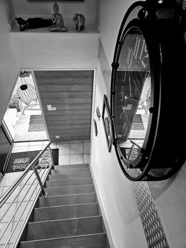 un escalier avec un miroir sur le côté du bâtiment dans l'établissement Rue des hautes lumières ouistreham Mer et campagne 3 chambres, à Saint-Aubin-dʼArquenay