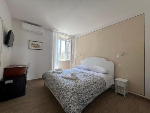 a bedroom with a bed and a television in it at La Dimora dei Magi in Saturnia