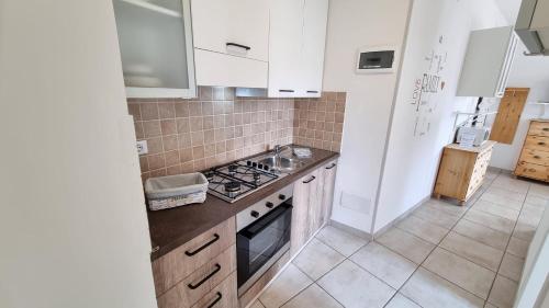 a kitchen with white cabinets and a stove top oven at Casa Carla in Peschiera del Garda