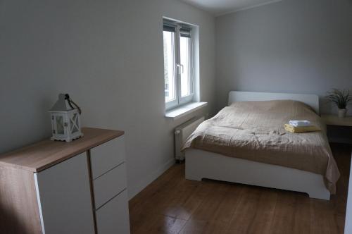 a bedroom with a bed and a window at Apartamenty z klimatem in Poznań