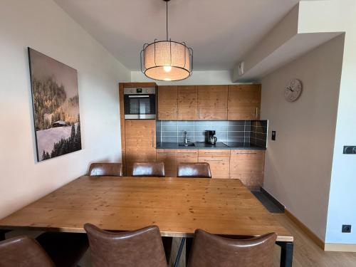 une salle à manger avec une table et des chaises en bois dans l'établissement Appartement Neuf aux Saisies - 6 Pers, 52m², 3 Pièces, Grand Balcon, Parking Couvert - FR-1-293-241, à Hauteluce