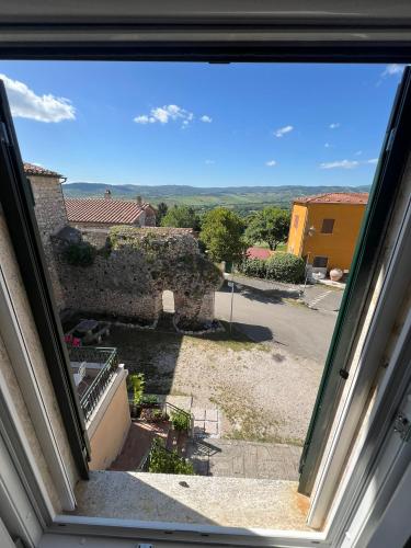 an open window with a view of a courtyard at La Dimora dei Magi in Saturnia