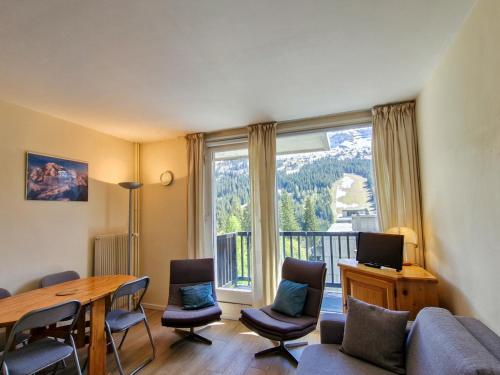 - un salon avec une table, des chaises et une grande fenêtre dans l'établissement Studio confort avec balcon sud, proche pistes et commerces, équipements pour 4 personnes - FR-1-425-183, à Flaine