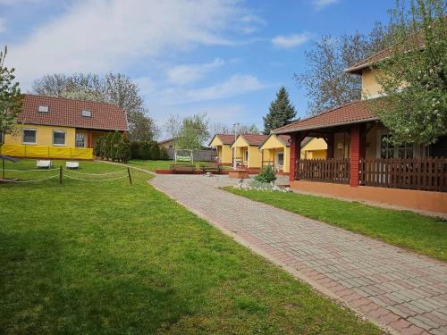 a row of houses in a yard with a driveway at Estike Apartmanok in Tiszafüred