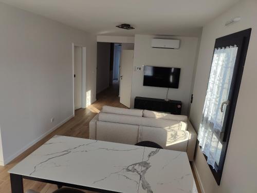 a living room with a couch and a table at L'Écrin Ludovicien Spa & chambres design aux portes de Bâle in Saint-Louis