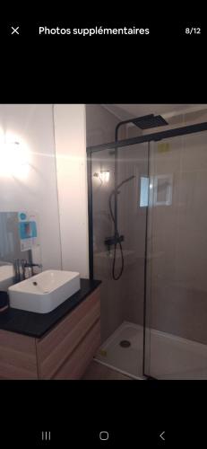 une salle de bain avec une douche en verre et un lavabo dans l'établissement Maison de charme, à Mireval