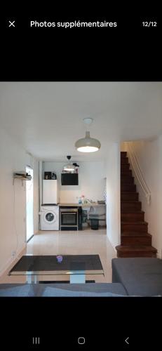 un salon avec un escalier et une cuisine dans l'établissement Maison de charme, à Mireval