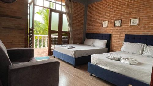 a bedroom with two beds and a couch and a chair at Casa Campestre Villateresita in Anapoima