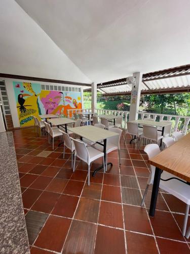 a restaurant with tables and chairs and a mural at Casa Campestre Villateresita in Anapoima