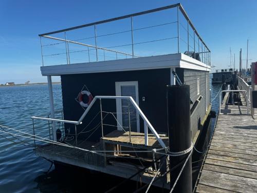 een klein huis op een boot op het water bij Hausboot Koje INE Huus & Meer in Ortmühle
