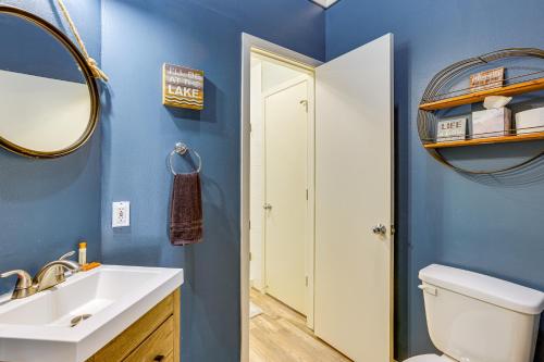 a bathroom with a toilet and a sink and a mirror at Exquisite Canal-Front Home Access to Lake Conroe! in Montgomery