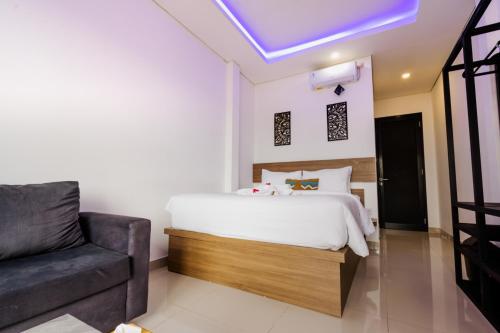 a bedroom with a bed and a couch at Homely Bali at Kayu Aya in Seminyak
