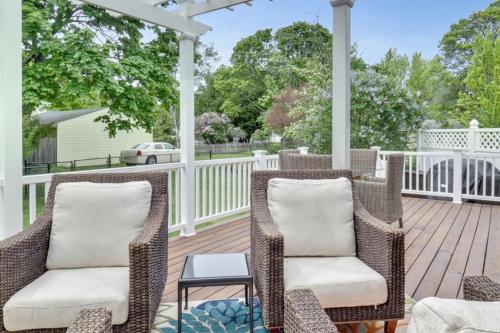 a porch with wicker chairs and a table at Hidden Gem Steps to Lake Michigan and Downtown! in Charlevoix