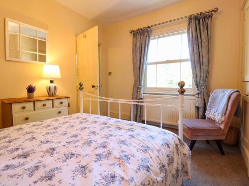 a bedroom with a bed and a window and a chair at Holmhurst in Southwell