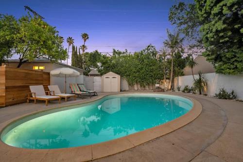 a swimming pool in a backyard with a table and chairs at Lake Balboa Hideaway in Los Angeles