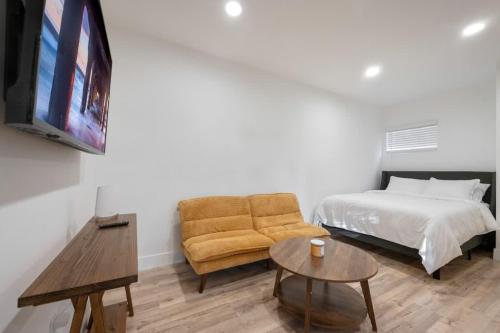 a bedroom with a bed and a couch and a tv at Lake Balboa Hideaway in Los Angeles
